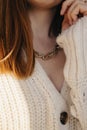 Close-up young woman in white sweater wearing golden chain necklace. Royalty Free Stock Photo