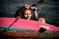 Close-up of young woman who holds rope and starts to stand on surf style wakeboard