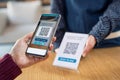 Customer hand scanning qr code with phone for digital payment