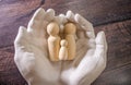 Close up of young women holding people shape male and female doll wooden peg dolls, family day, warmth, happiness