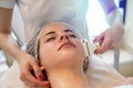 Close up of young woman receiving electric ultrusound facial massage at beauty salon.