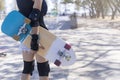 Close up on young women wear protection and hand hold skateboard, surf skate on public skate ramp park background. Free relax