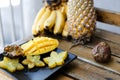 Close up yummy mango with carambola on plate near pine-apple and bananas on wooden table.