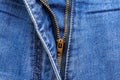 Close up of a zipper half unzipped on a of blue jeans. Jeans macro texture