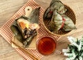 Close up Zongzi or rice dumpling on the wooden table with Chinese tea in Dragon Boat Festival, Asian traditional food