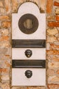 Close-ups of building facades in Venice, Italy. An old vintage intercom and a mailbox on a stone wall. On door where