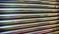 Close-ups of colorful reflective industrially manufactured metal pipes stored next to each other after production