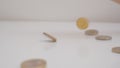 Close-ups of euro coins scatter from the sky on a white background. A metaphor for godliness