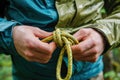 Close-ups of hands tying knots for outdoor activities. Colorful rope.