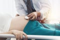 Close-ups, a pregnant woman`s health care doctor, a male doctor, a pediatrician, uses a stethoscope to listen to the fetus during