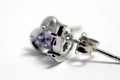 Close ups shot of white golden heart shaped ear stud with purple crystals gem