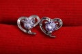 Close ups shot of white golden heart shaped ear stud with purple crystals gem