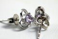 Close ups shot of white golden heart shaped ear stud with purple crystals gem