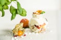 Close upshot of vanilla ice cream with multiple fruits in a cute glass jar decorated with a flower