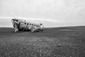 Close view of an abandoned crashed plane on a flat black sand land