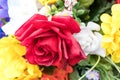 Close view of an assortment of artificial flowers with a red rose in the center Royalty Free Stock Photo