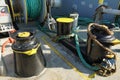 Close view on black and yellow painted bollards and mooring roller in forward manoeuvring station on cargo container vessel. Royalty Free Stock Photo