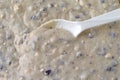 Close view of blueberry muffin mixed with milk plus a spoon