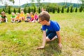 Close view of boy standing on his knees, group of kids behind him Royalty Free Stock Photo