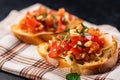 close view of bruschetta with pickled garlic on a crisscrossed napkin