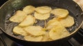 Close view of a bunch of potato slices being fried