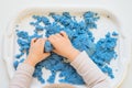 Close view of child`s hands playing with kinetic sand. Royalty Free Stock Photo