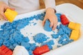 Close view of child`s hands playing with kinetic sand. Royalty Free Stock Photo