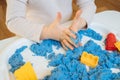 Close view of child`s hands playing with kinetic sand. Royalty Free Stock Photo