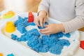 Close view of child`s hands playing with kinetic sand. Royalty Free Stock Photo