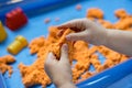 Close view of child`s hands playing with kinetic sand. Royalty Free Stock Photo