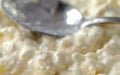 Close view cottage cheese and pineapple chunks with a spoon in the background Royalty Free Stock Photo