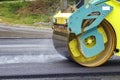 Drum roller at the construction site, working on the new road with smoke Royalty Free Stock Photo