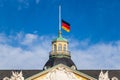 Close view on German Flag at Halfmast, auf Halbmast, on the tower roof of Castle Karlsruhe. Baden-WÃÂ¼rttemberg, Germany Royalty Free Stock Photo