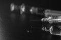 Close view of the glass syringes on a black background. Medicine and health concept. Vaccine against viruses. Needle and drugs. Royalty Free Stock Photo