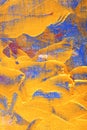 Close View of gold paint brought on blue canvas vivid blue red white paintstrokese canvas Royalty Free Stock Photo