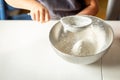 a close view of the hand of the child sifting flour