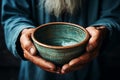 Close view hands of an elderly man hold an empty bowl, conveying povertys challenges