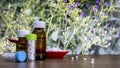 Close view of Homeopathic medicine consisting of pills in red spoon and bottle of liquid and globules substance with spread white Royalty Free Stock Photo