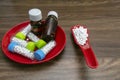Close view image of Homeopathic medicine substance bottles in red plate and pills in red spoon on wood background Royalty Free Stock Photo