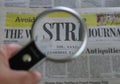 Close view on international newspapers with a magnifying glass and a soft bokeh