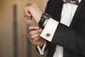Close view of the luxury watches on the hand of a handsome businessman in a tuxedo and in a shirt with cufflinks Royalty Free Stock Photo