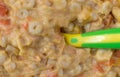 Close view of macaroni and cheese baby food with a spoon in the food