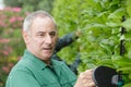 close view mature man using hedge cutter