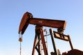 Old rusty oil derrick in sunlight with blue sky Royalty Free Stock Photo