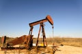 Old rusty oil derrick in sunlight with blue sky Royalty Free Stock Photo