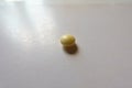 Close view of one round yellow pill of xylitol