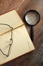 Close View of Reading Glasses and Magnifier on Large Antique Book Royalty Free Stock Photo