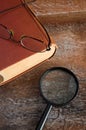 Close View of Reading Glasses and Magnifier on Large Antique Book Royalty Free Stock Photo