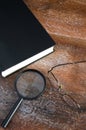 Close View of Reading Glasses and Magnifier on Large Black Book Royalty Free Stock Photo