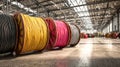 Close view of several multicolored cable spools placed on the floor of an industrial warehouse, featuring a large open space with Royalty Free Stock Photo